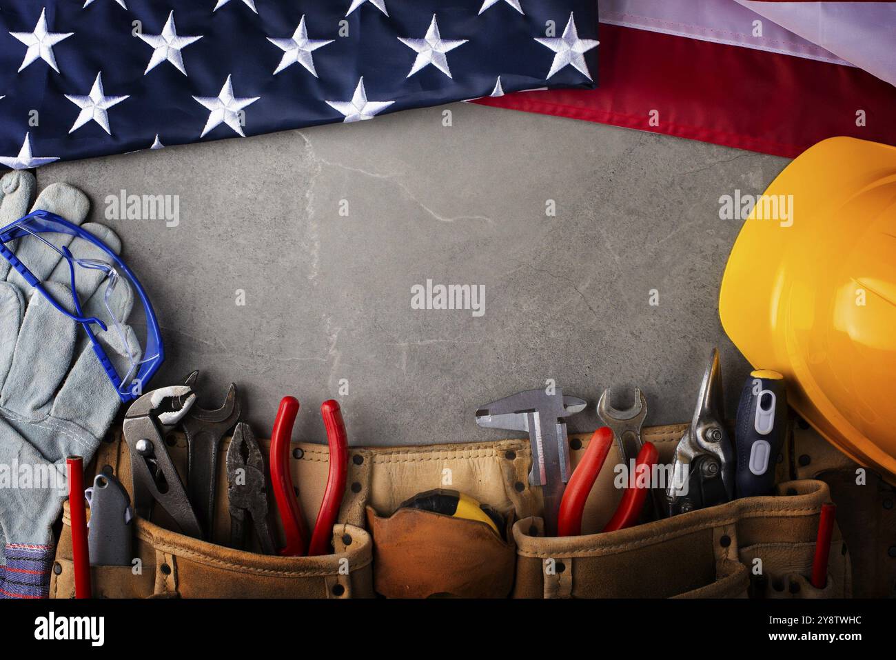 Tools hardhat toolbelt and us flag on concrete cement background labor day banner mockup Stock Photo