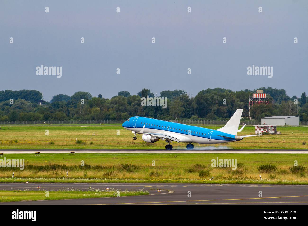 Blue Airplane Landing on Green Runway Stock Photo - Alamy