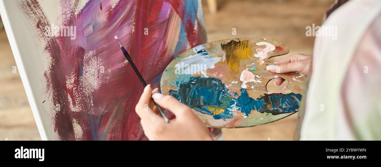 A young woman enjoys expressing her creativity by painting at home ...