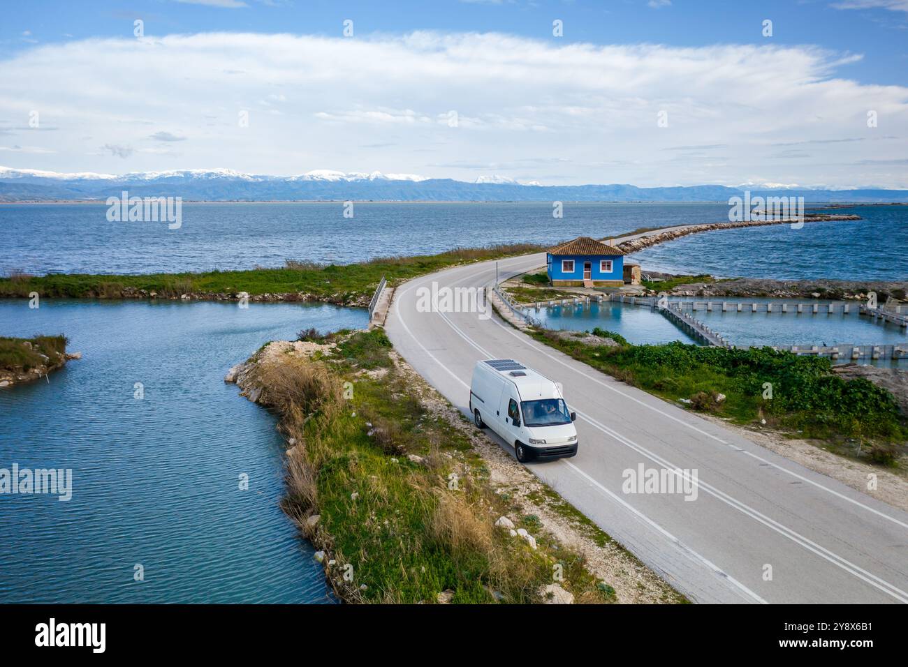 Drone view of camper van on a road with curves between two lakes Stock Photo