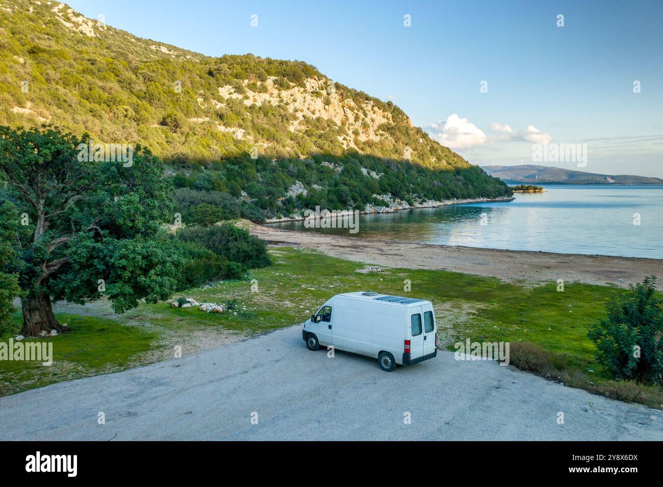 Drone view of camper van with roof solar panels on a wild beach Stock Photo