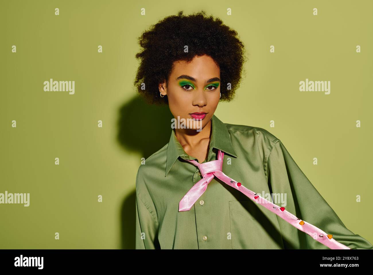 A young woman with expressive features showcases her emotional depth in a lively, green ambiance. Stock Photo