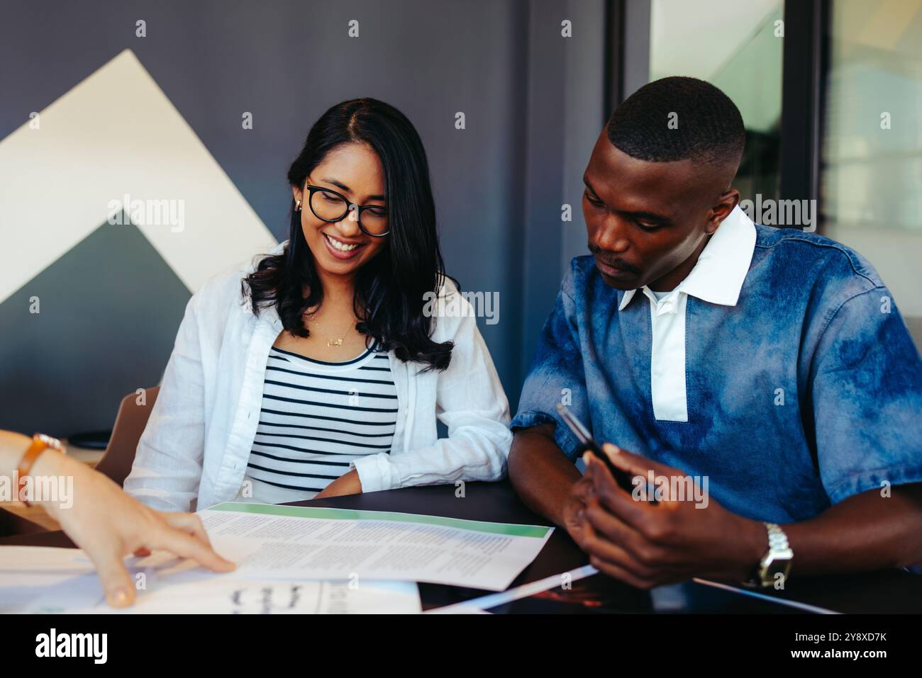 College students collaborate in a modern learning environment, exchanging ideas and focused on project work. Stock Photo