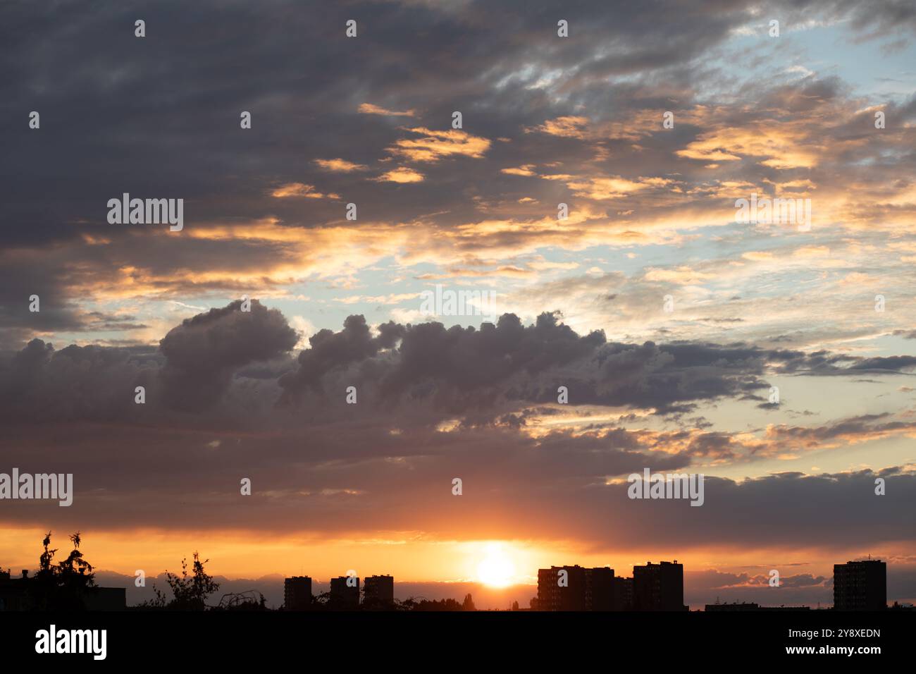 Sunrise sky above a city. Incredible natural colors. Red, orange, blue. Heaven. Stock Photo