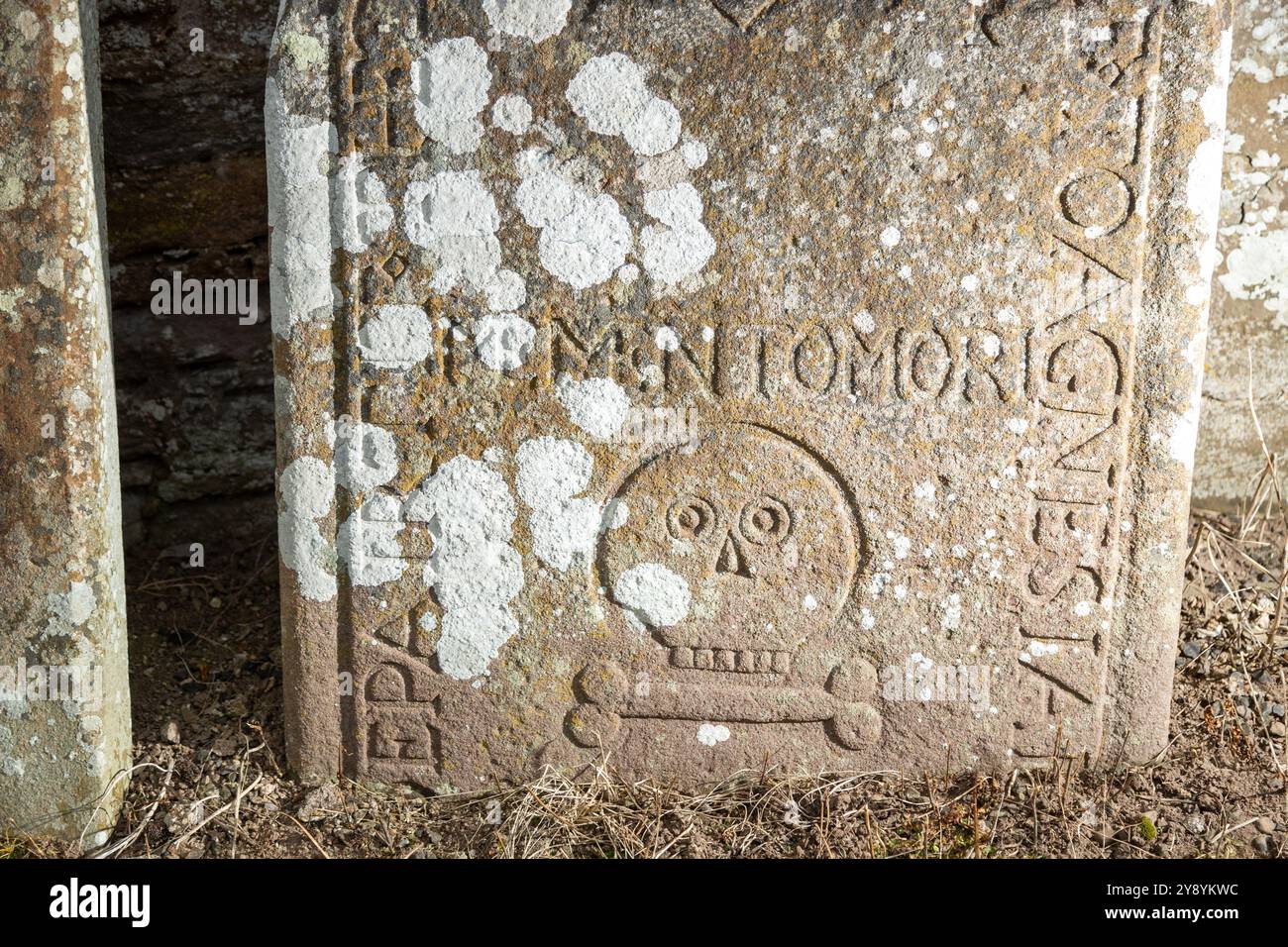 Ancient Gravestone carved with a simplistic skull and single bone, Eassie Church, Angus, Scotland Stock Photo