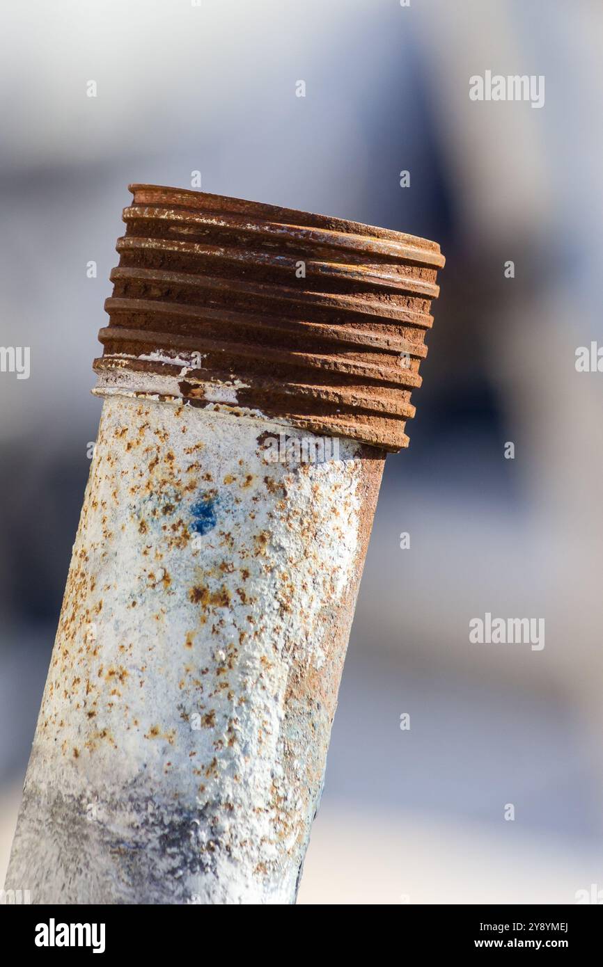 a rusty metal pipe with thread on a blurred background Stock Photo