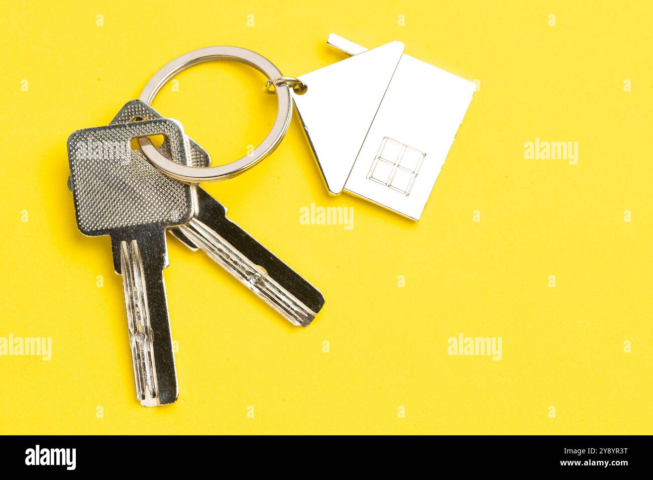 Yellow Key Real House keys with house shaped keychain on yellow background. Real estate ...