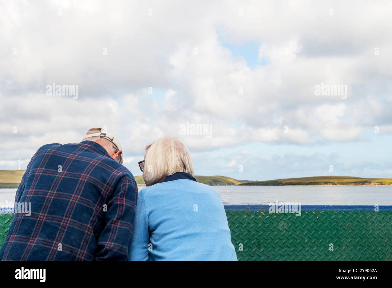 Senior couple looking out from ferry between islands of Yell and Fetlar, Shetland. Stock Photo