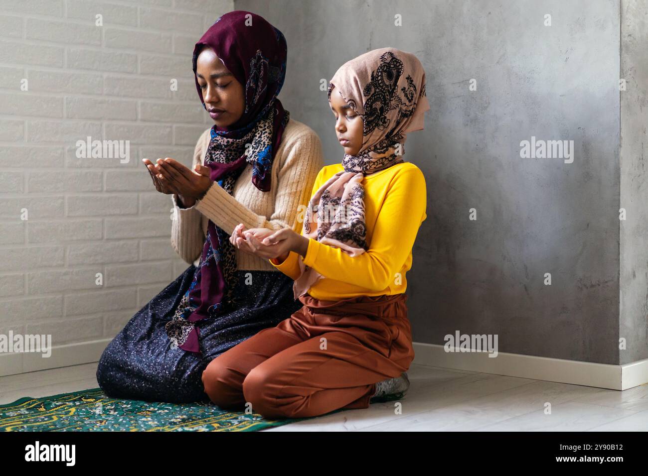 Praying and teaching, child and adult praying together Stock Photo - Alamy