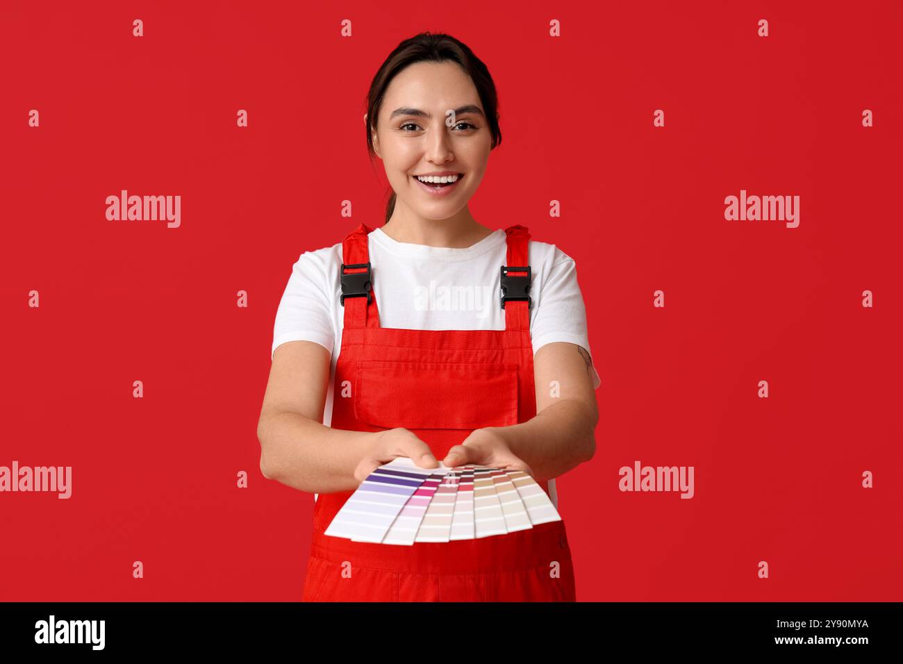 Female painter with color palettes on red background Stock Photo - Alamy