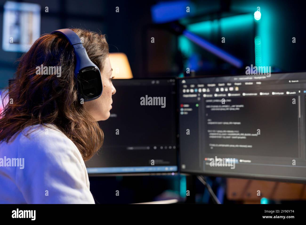 Engineer enjoying podcasts and futureproofing company network from downtimes and unexpected system failures. IT specialist putting headphones on to listen audiobooks while increasing data security Stock Photo
