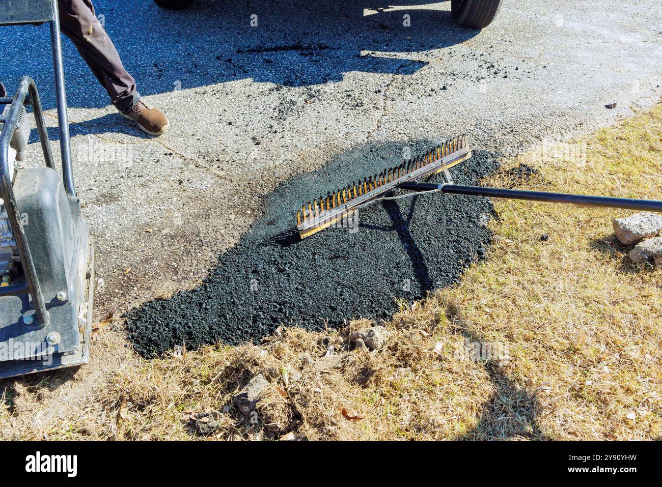 Workers small repair potholes on road by asphalting damaged asphalt Stock Photo