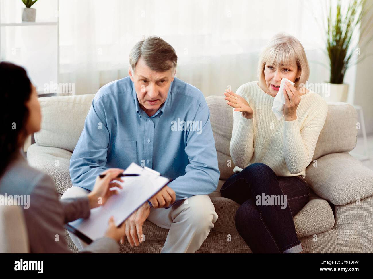 Senior couple in therapy working out problems with counselor Stock Photo