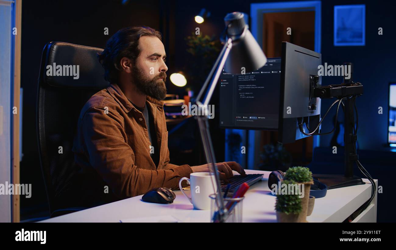 Developer overthinking solutions while doing programming during remote job shift in home office. IT admin working on computer in apartment late at night, thinking how to fix bugs, camera B Stock Photo