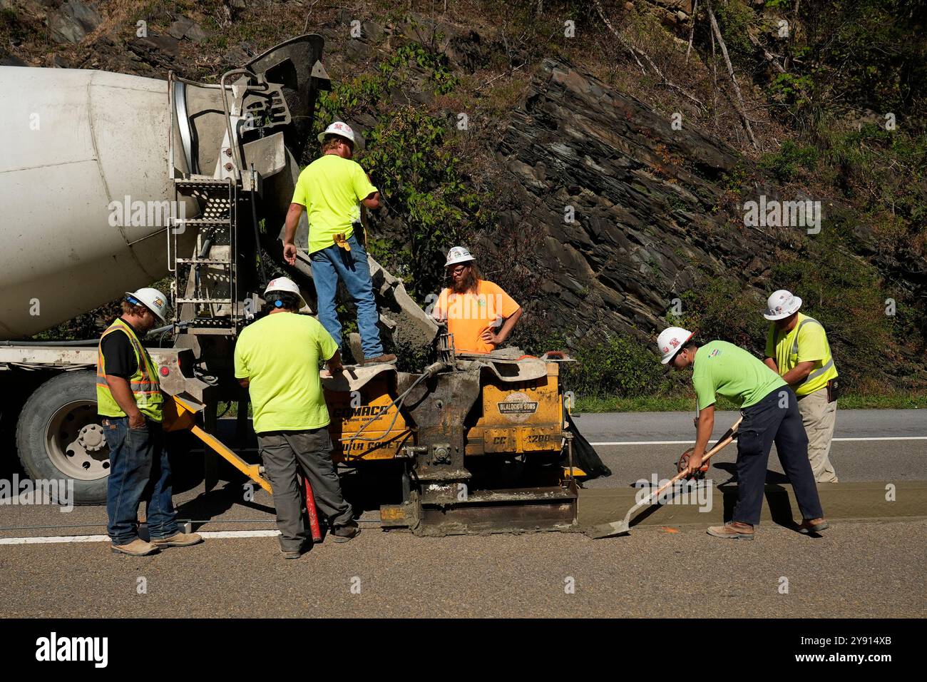 Construction workers build a barrier along westbound lanes on ...