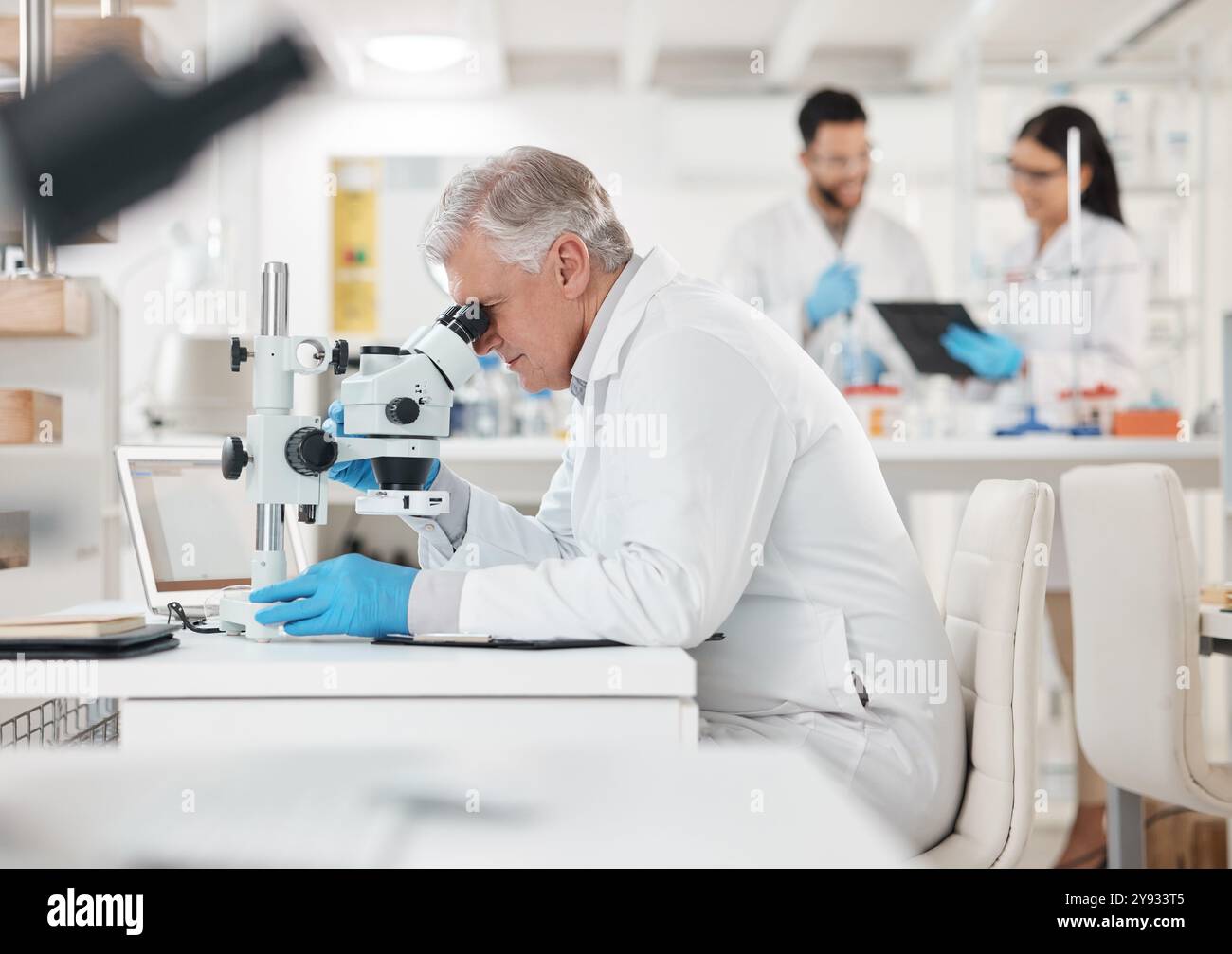 Science, research and mature man with microscope in laboratory ...