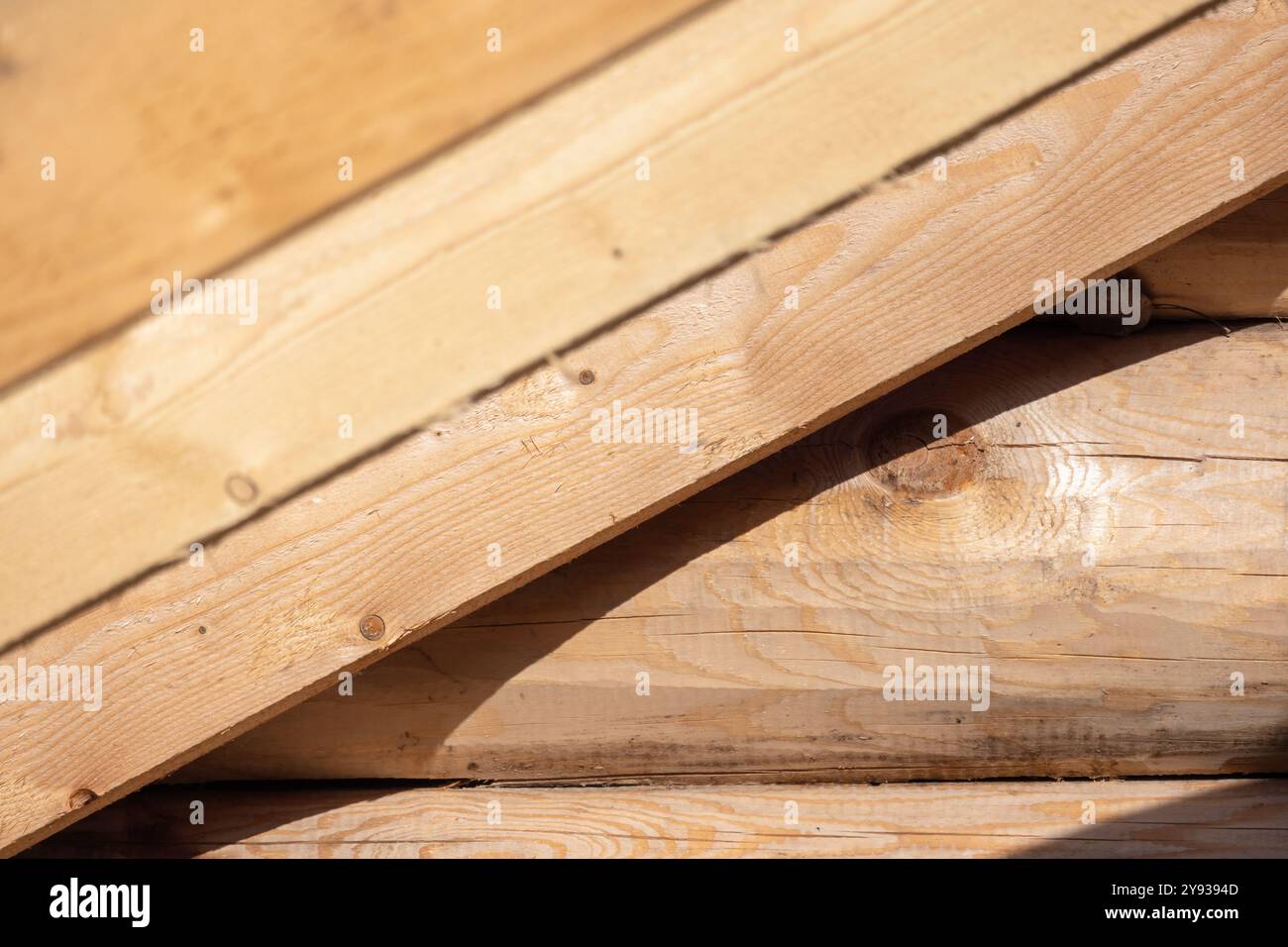 Roof rafters and a wall made of logs. Background photo with selective ...
