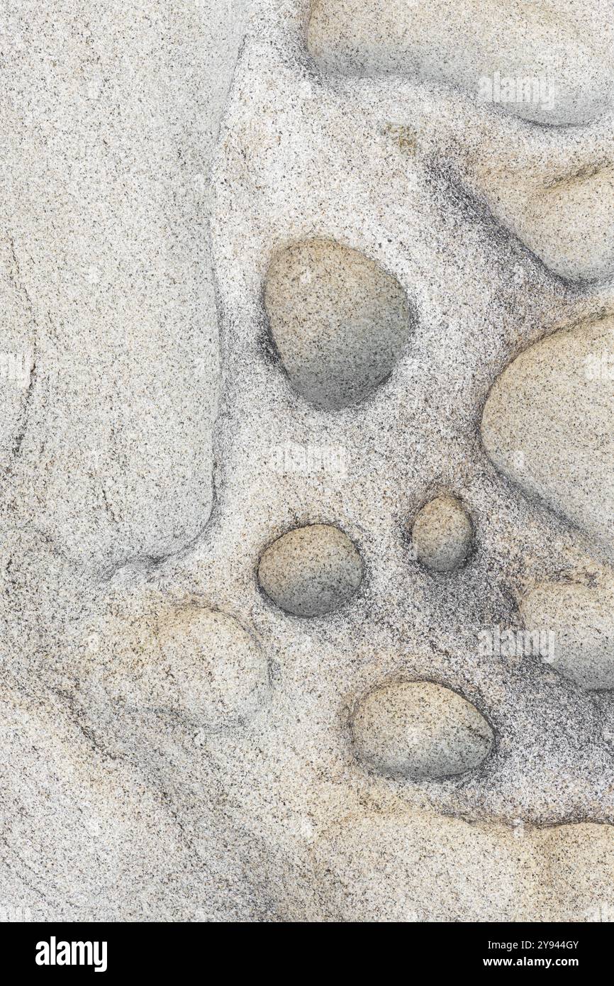 This image captures the intricate patterns and subtle colors of a natural sandstone surface, highlighting its smooth textures and circular indentation Stock Photo