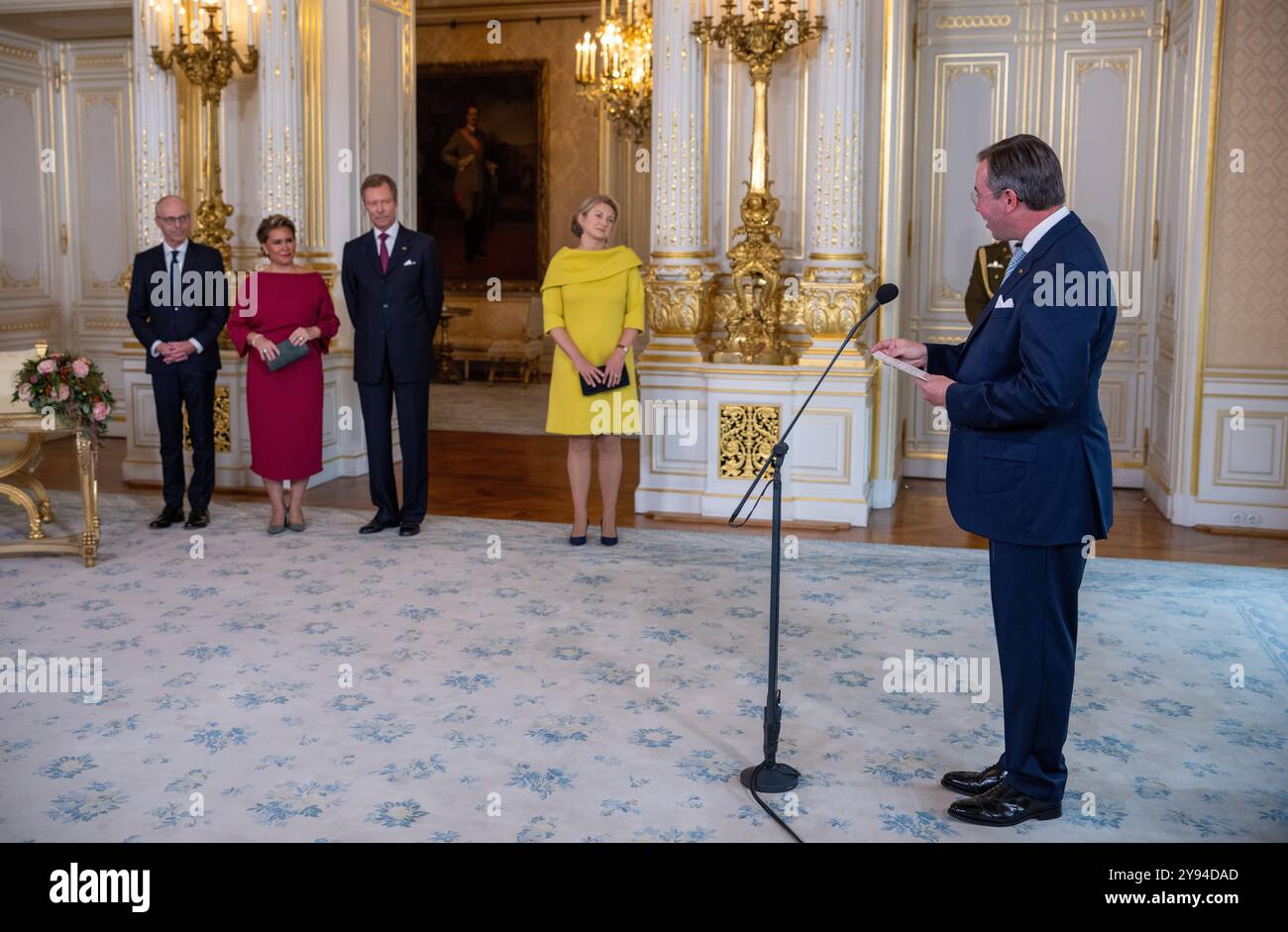 08 October 2024, Luxembourg, Luxemburg: Prince Guillaume (r), Hereditary Grand Duke of Luxembourg, thanks Luc Frieden (l-M), Prime Minister of Luxembourg, his mother, Grand Duchess Maria Teresa, his father, Grand Duke Henri, and his wife Princess Stephanie in the ducal palace after his appointment as 'Lieutenant-Représentant' (honorary lieutenant). Grand Duke Henri has appointed his son Prince Guillaume as Governor, thus initiating the handover of office. The 42-year-old now takes over certain tasks from his father, while the latter remains Head of State. Photo: Harald Tittel/dpa Stock Photo