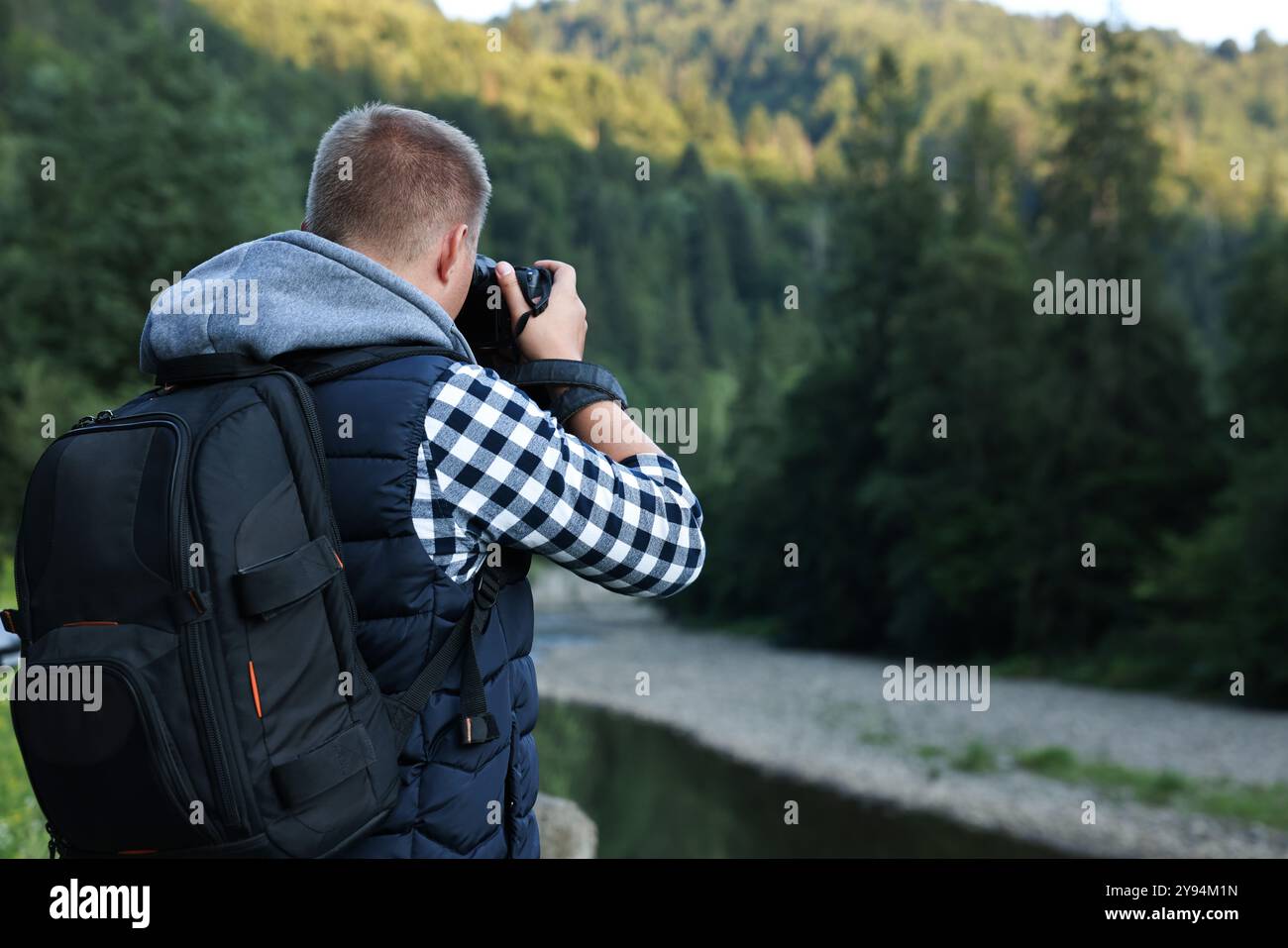Photographer Back Photographer with backpack and camera taking picture of beautiful ...