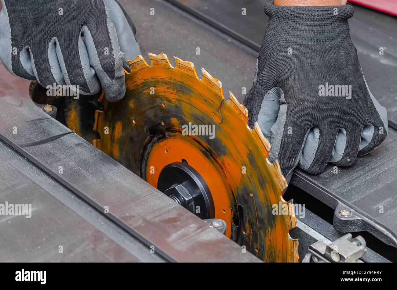 carpenter replaces a circular saw in a machine tool. Replacing the saw ...