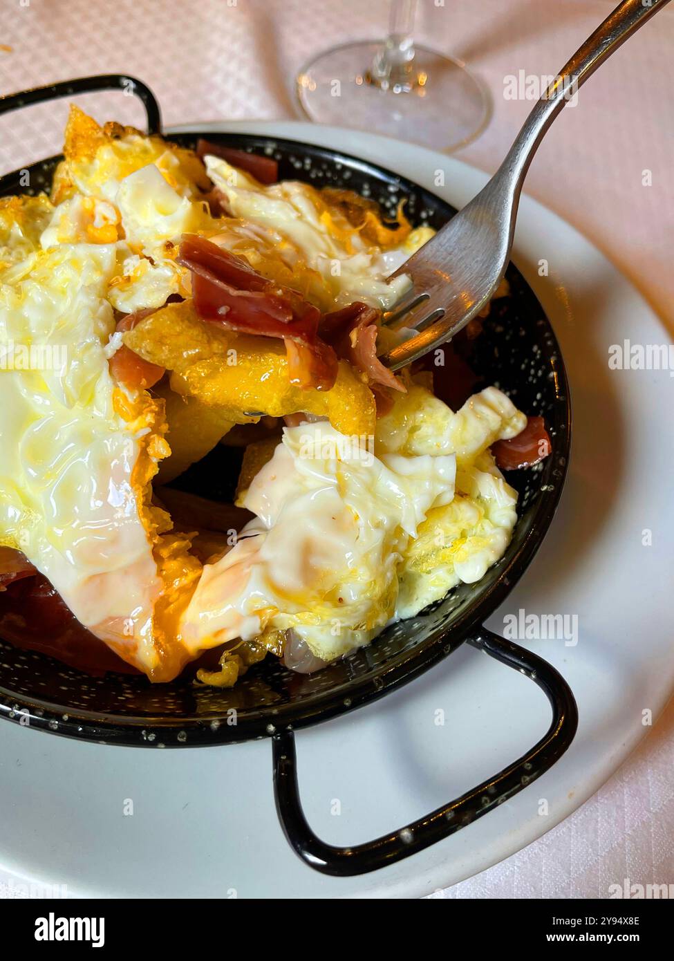 Eating scrambled eggs with ham and potatoes. Spain. - Smartphone Captured Stock Image