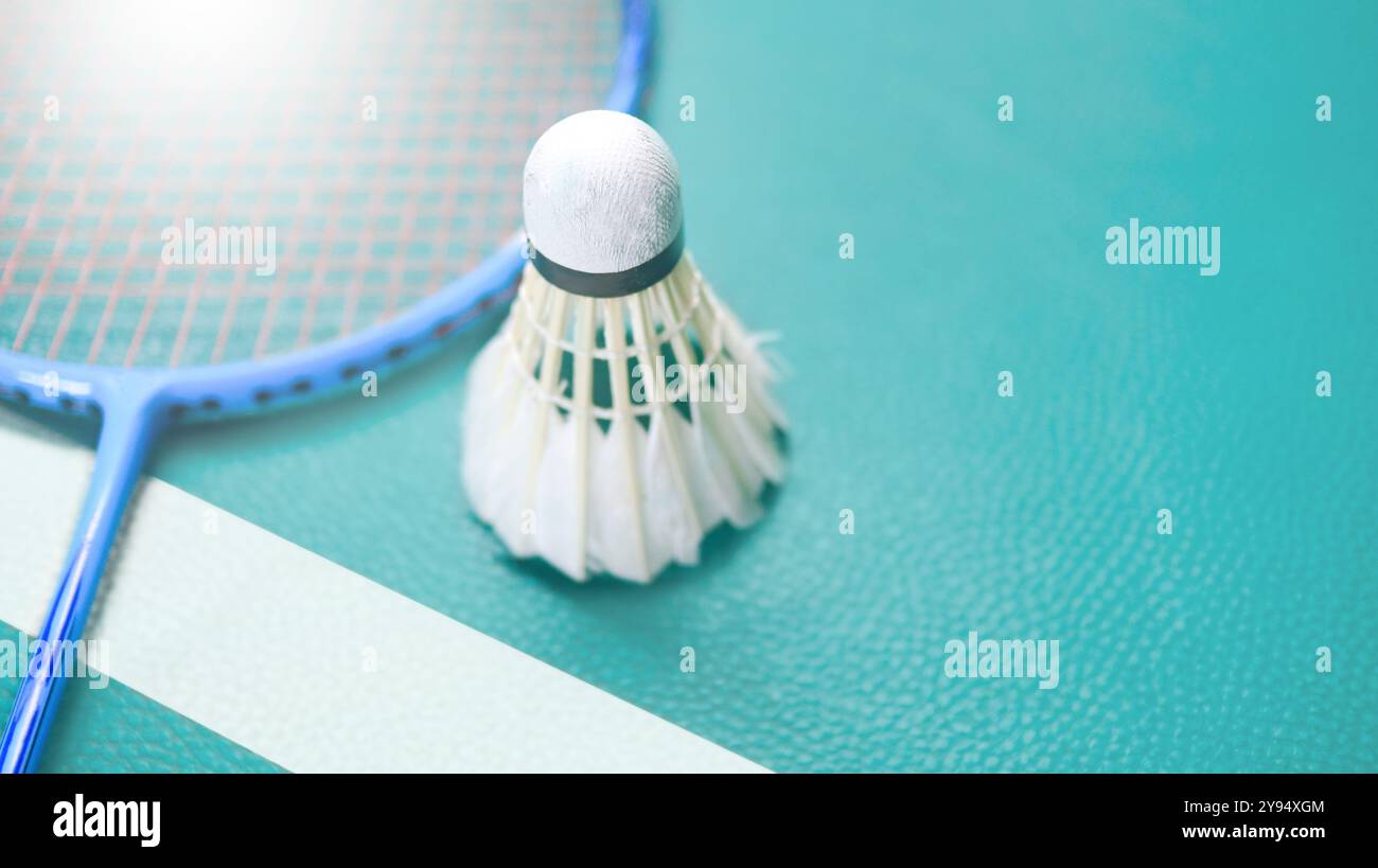 White badminton shuttlecocks and badminton rackets on green floor ...