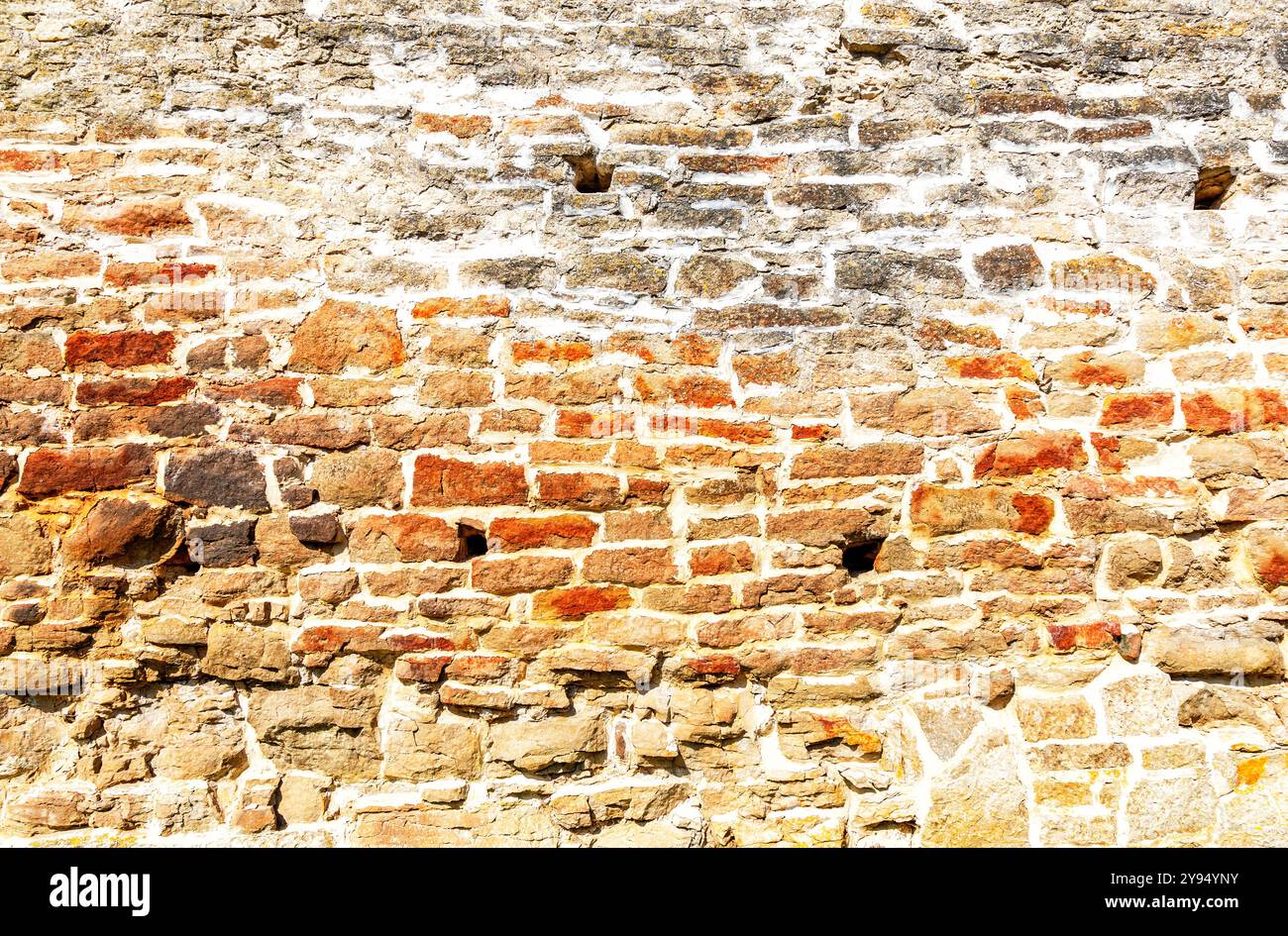 Ancient weathered rough stone wall as creative background. Grunge brick wall texture background Stock Photo