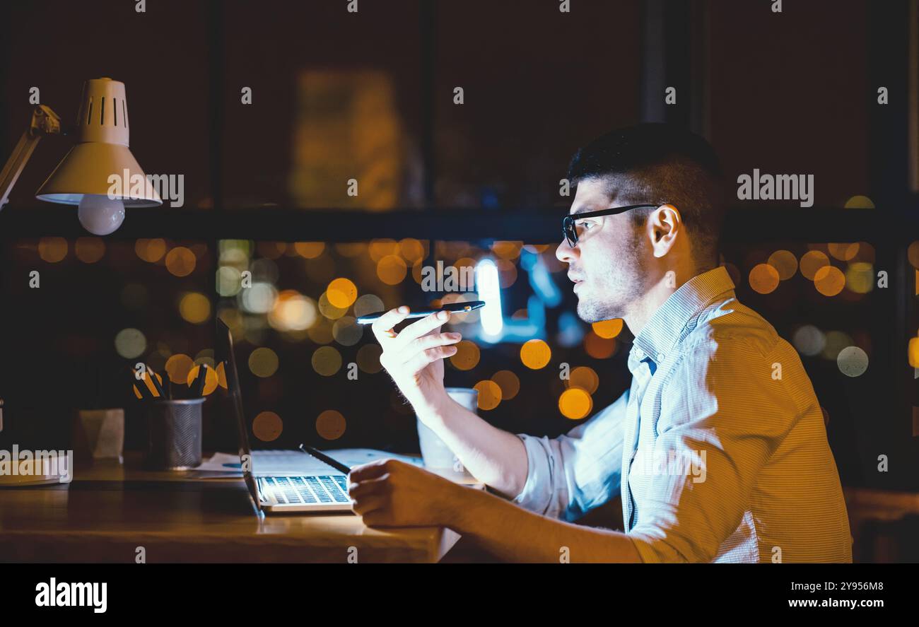 Serious Entrepreneur Using Loudspeaker Talking On Cellphone In Modern Office Stock Photo