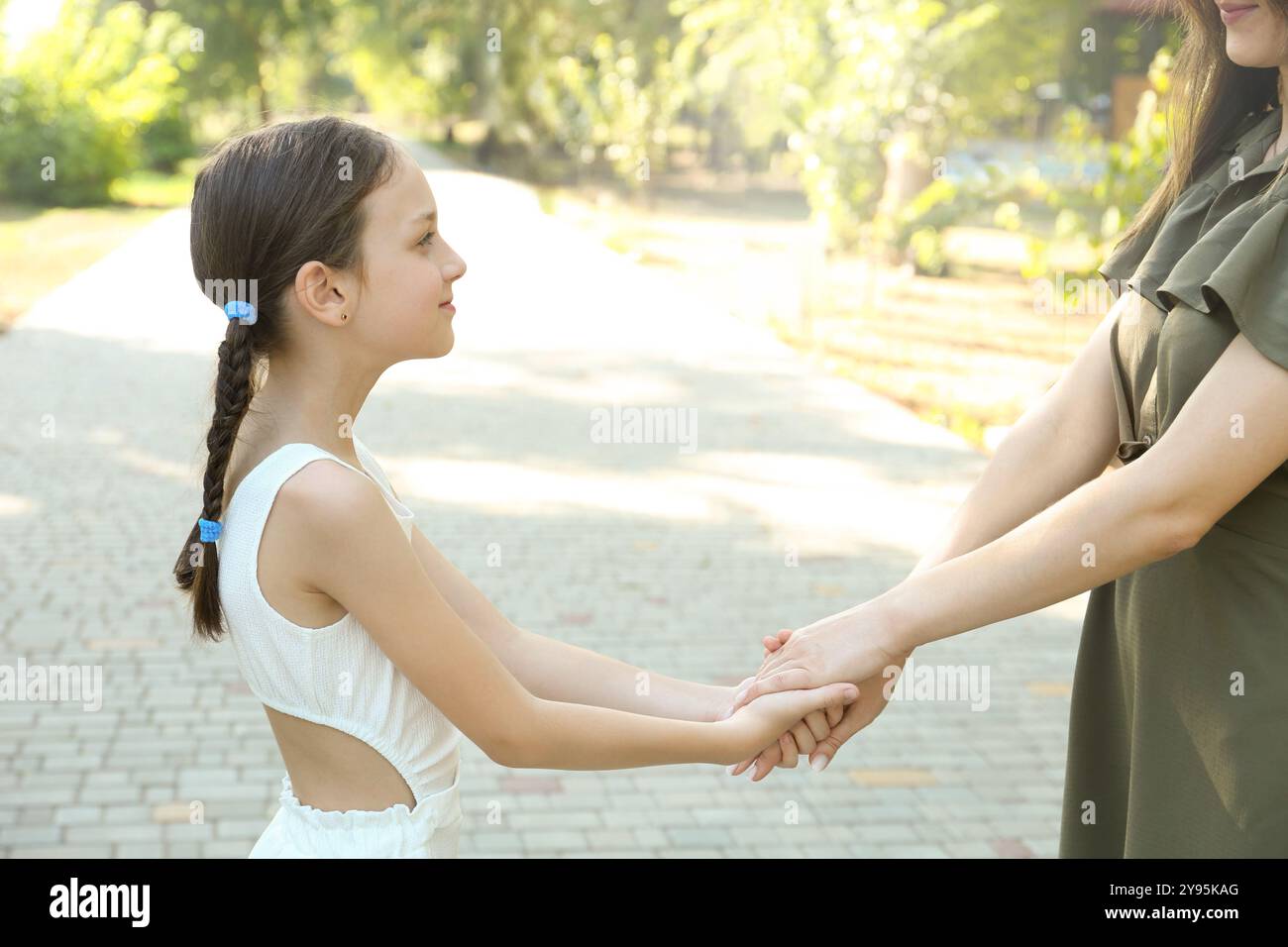 Little girl holding hands with mother in park, closeup Stock Photo - Alamy