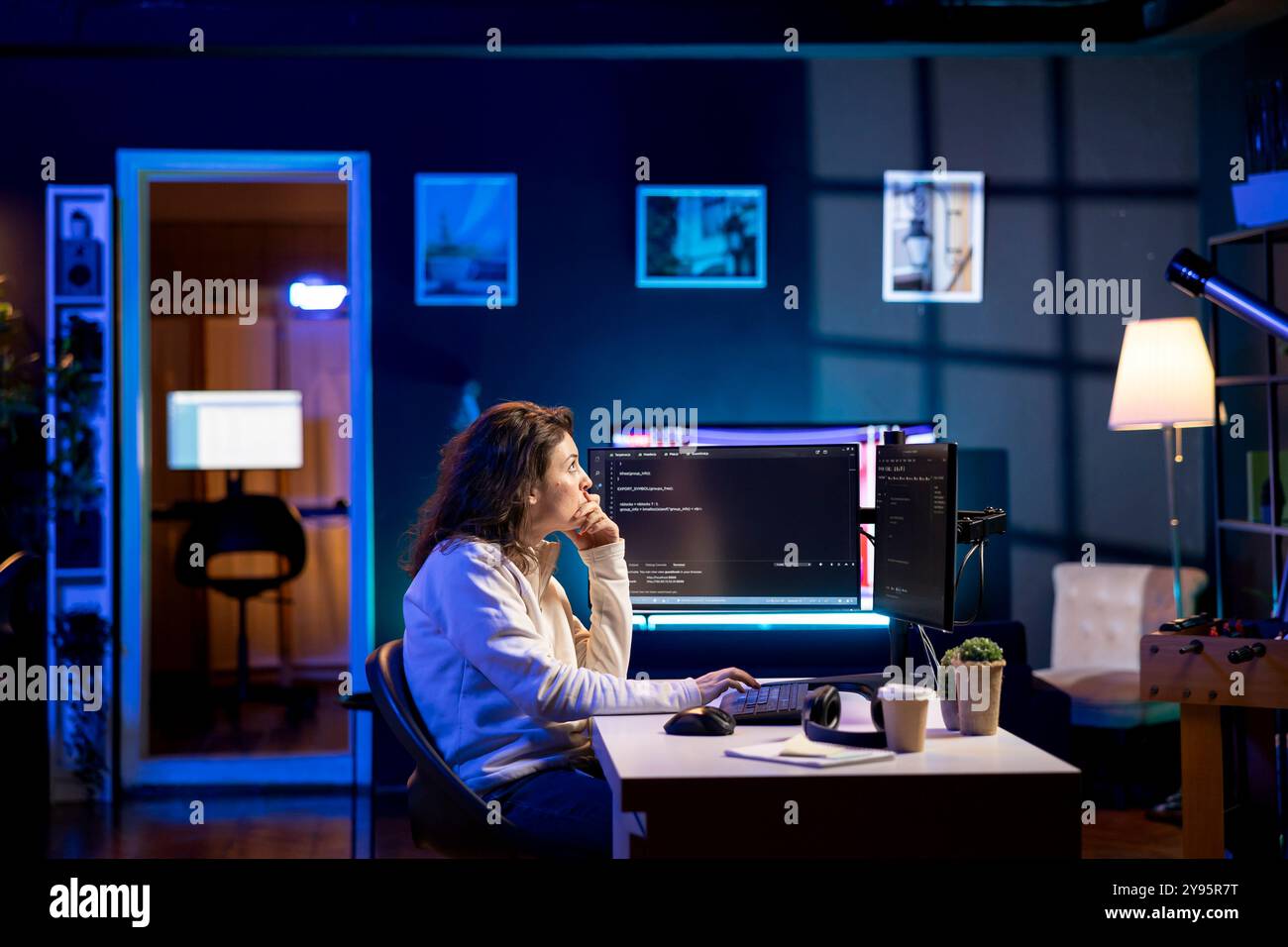 System administrator doing software debugging on PC at home, checking broken lines of code displayed on AR hologram. IT professional in living room fixing coding problems using augmented reality Stock Photo