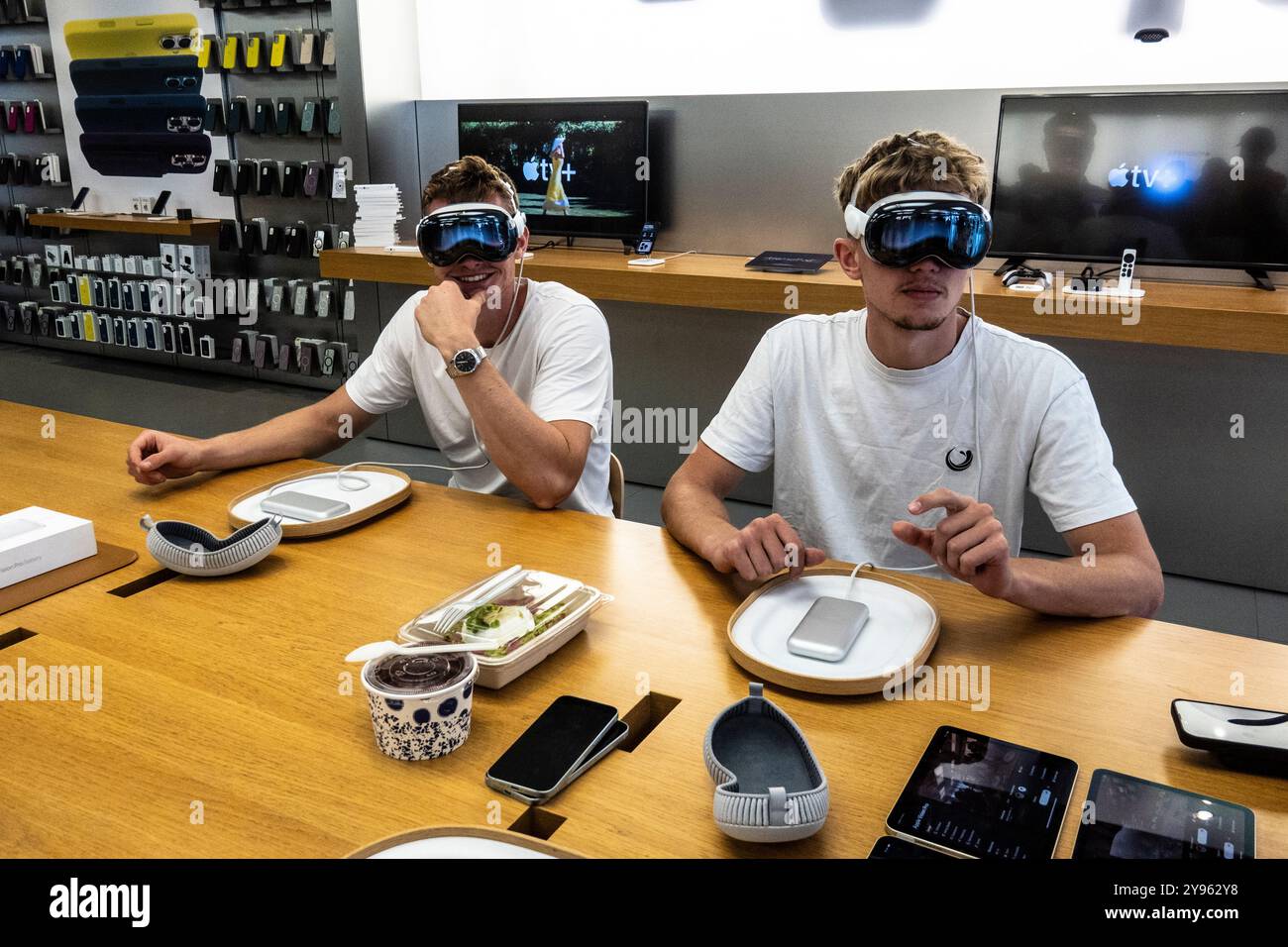 College aged men trying on an Apple Vision Pro VR headset in the Apple