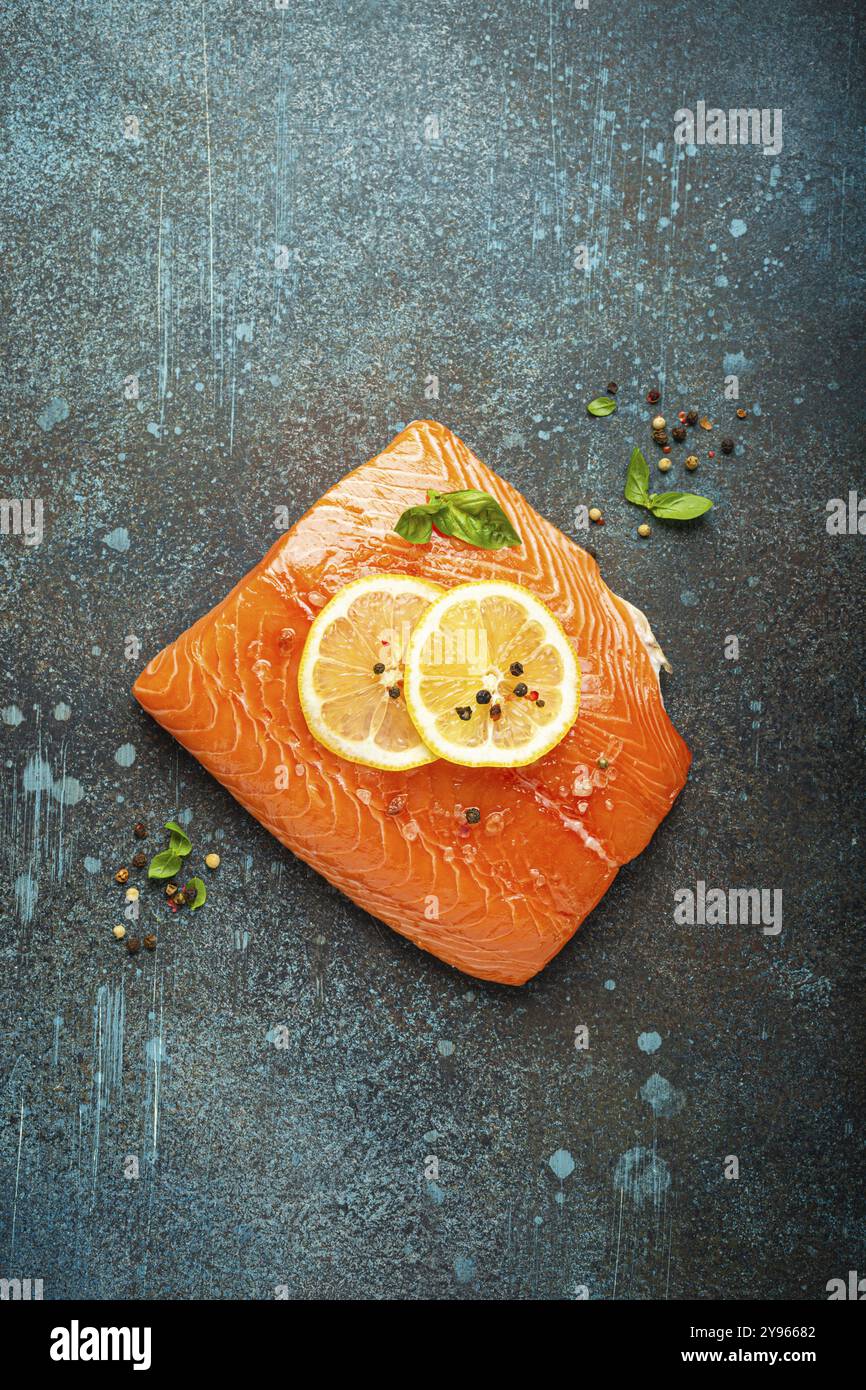 Fresh raw salmon marbled fillet on dark blue rustic concrete table ...