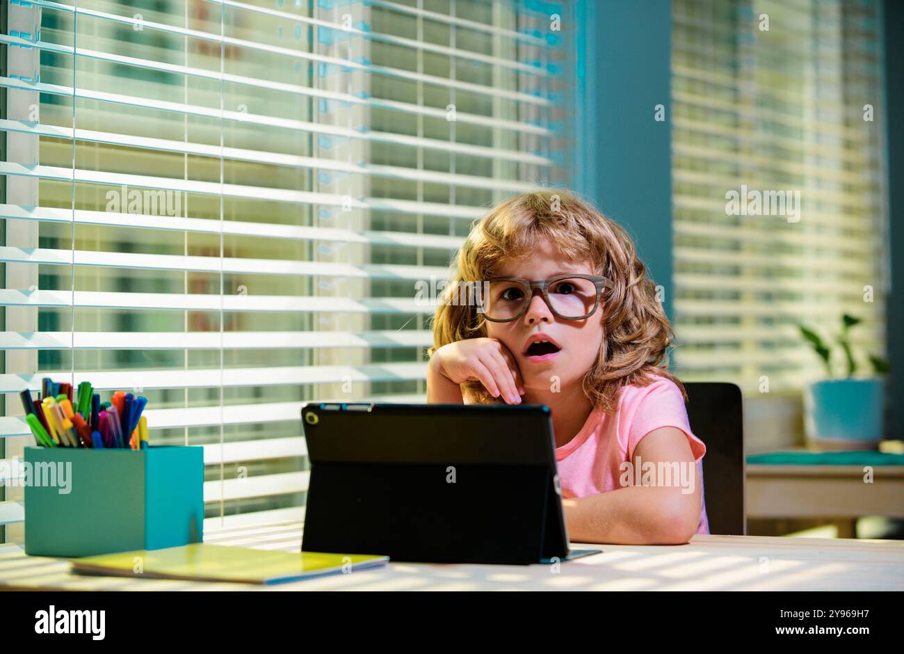 School pupil studying online, learning on laptop tablet doing homework ...