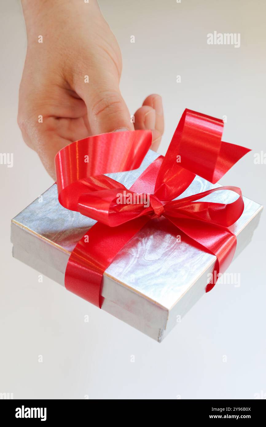 Silver gift box with red ribbon bow on white background Stock Photo