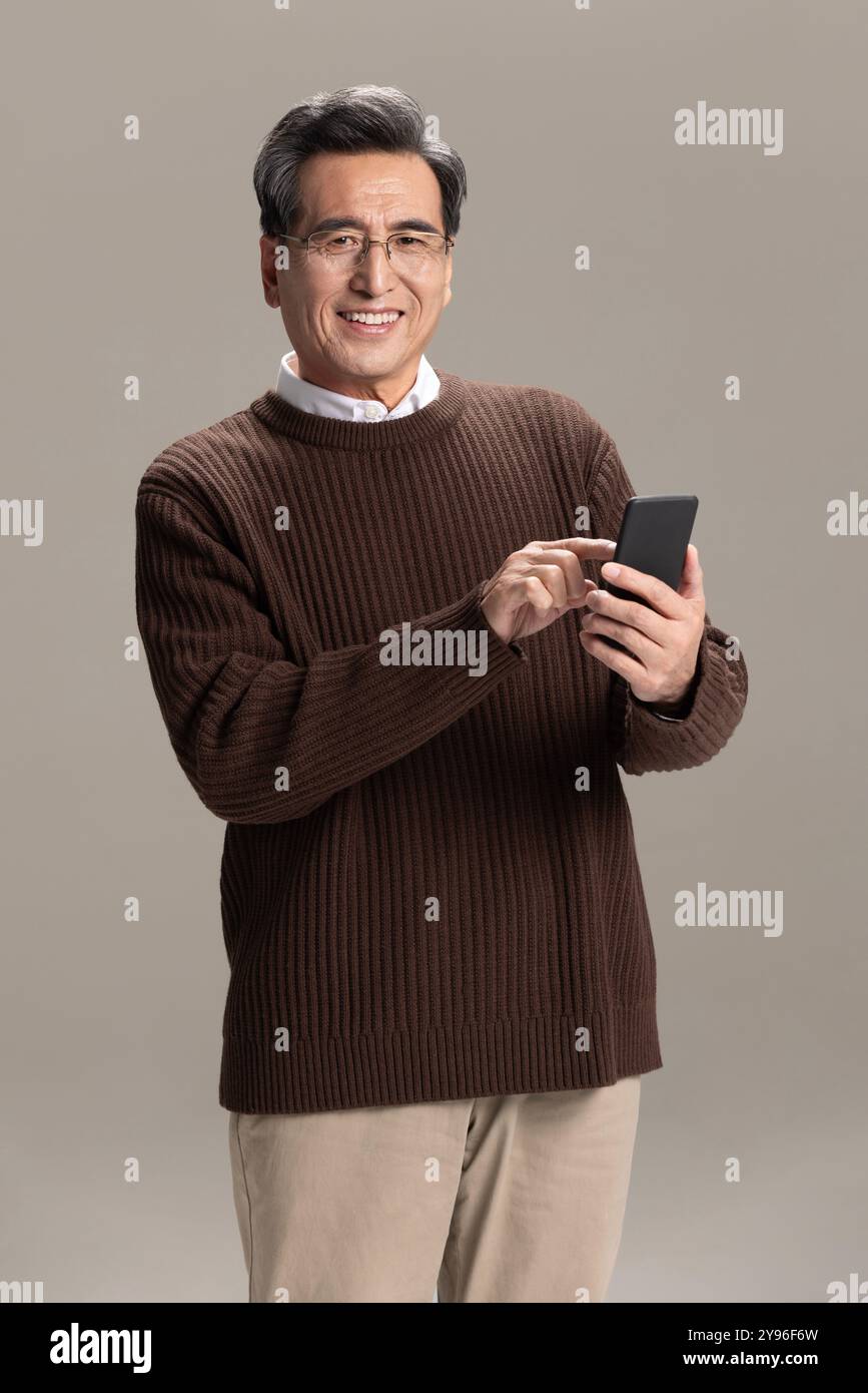 Happy senior man using smart phone Stock Photo