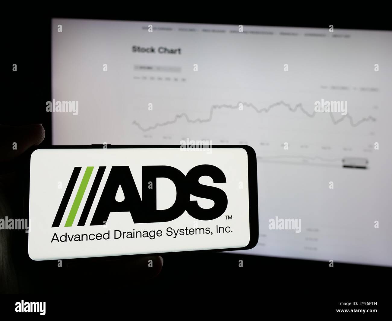Person holding mobile phone with logo of US company Advanced Drainage ...