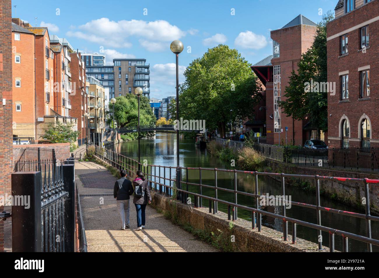 View of the Kennet & Avon Canal through Reading town centre with people walking beside the canal and waterside properties, Berkshire, England, UK Stock Photo