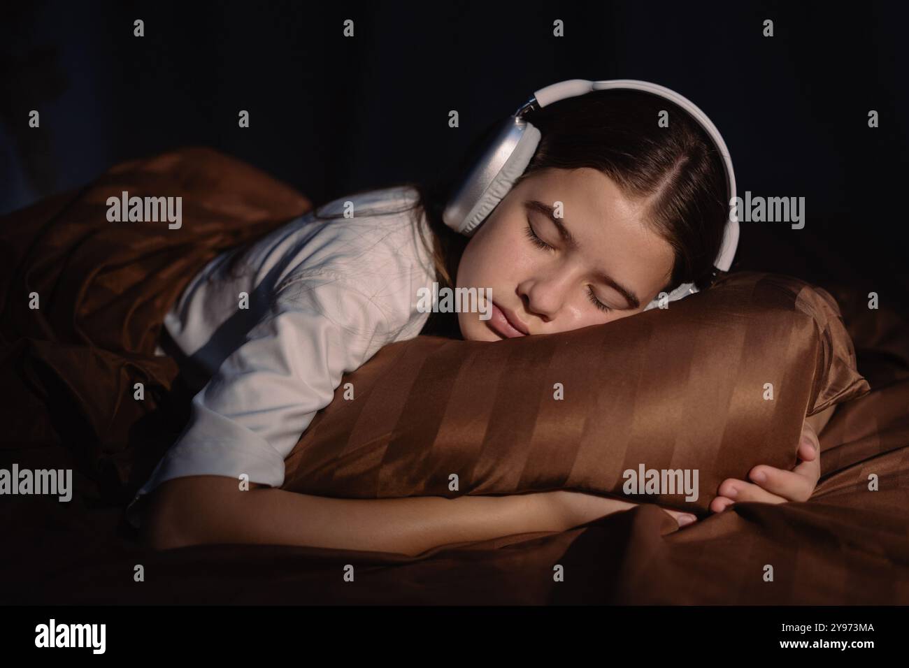 Teen girl sleeping in bed wearing headphones Stock Photo - Alamy