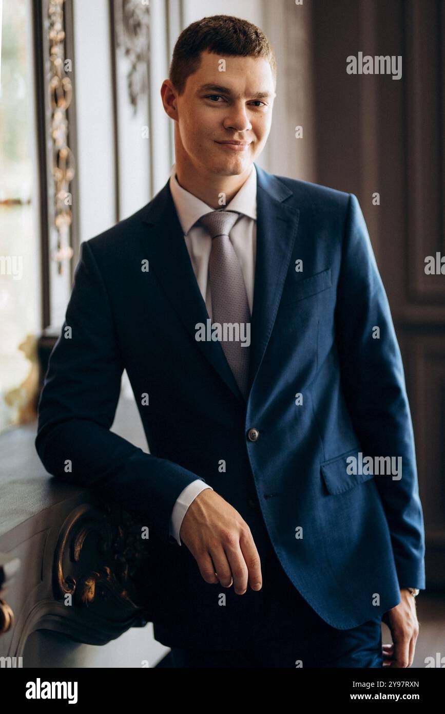 portrait of groom in blue three piece suit with tie on wedding day in hotel Stock Photo