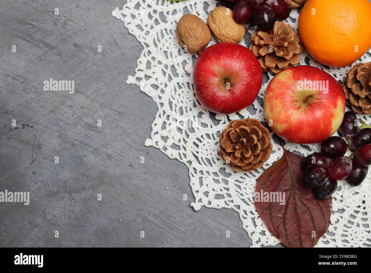 Autumn composition with apples, walnuts and leaves on grey background Stock Photo