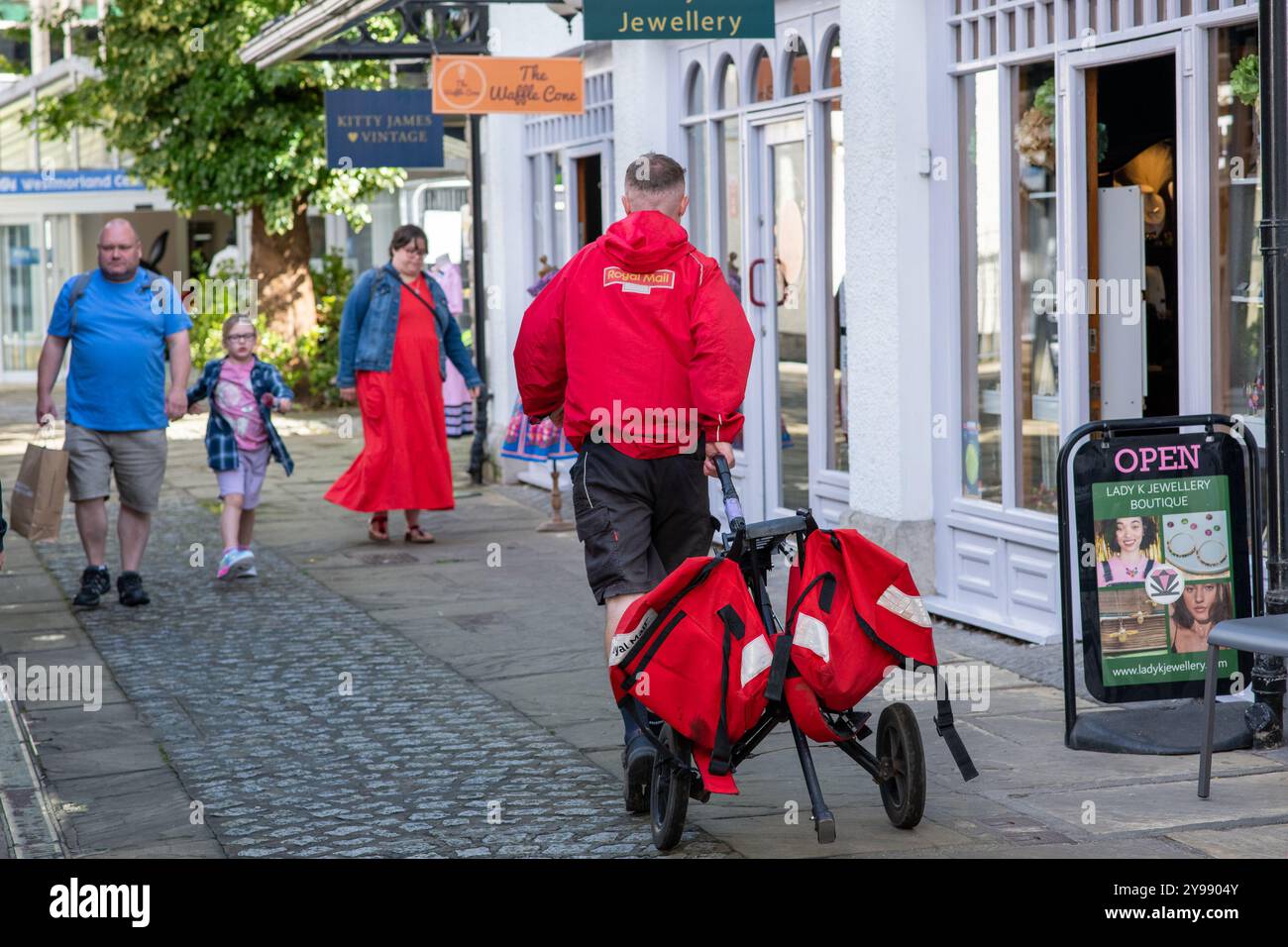A Royal Mail postman delivering post, Kendal, Cumbria, UK Stock Photo