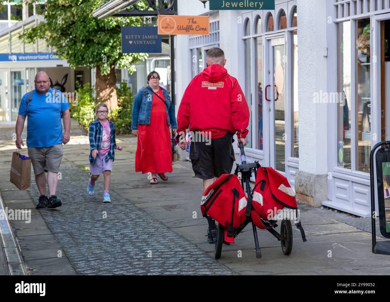 A Royal Mail postman delivering post, Kendal, Cumbria, UK Stock Photo