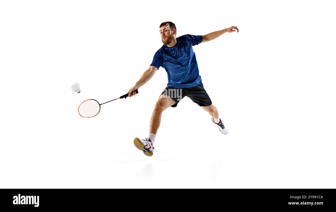Male player reaches out to hit shuttlecock with precision against white ...