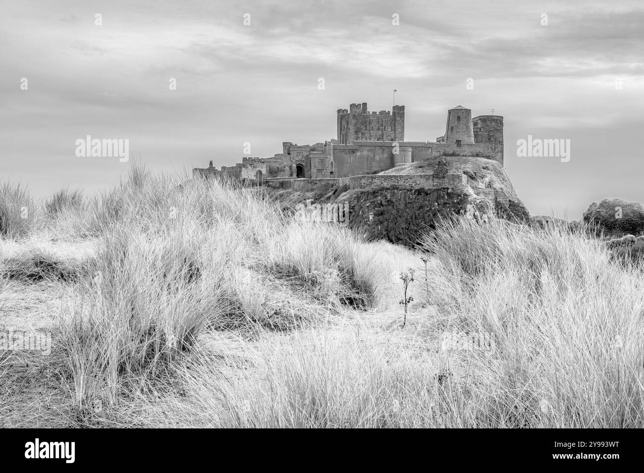 The image is of the medieval castle of Bamburgh that overlooks Embleton Bay and the North Sea in Northumberland on the northeast coast of England Stock Photo