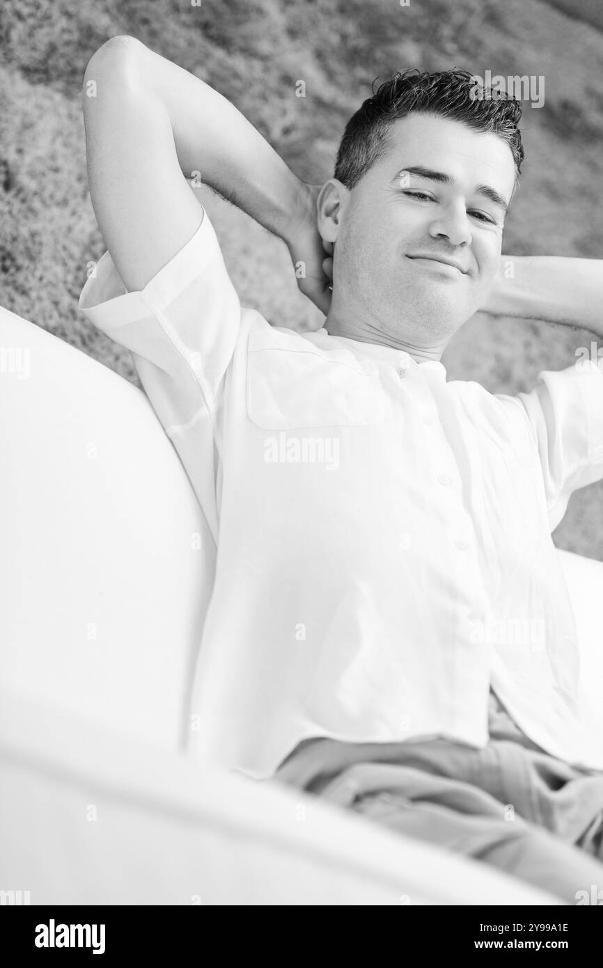 Man sitting hands behind head Black and White Stock Photos & Images - Alamy