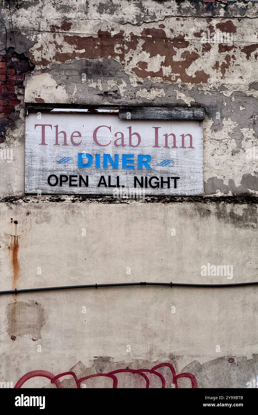 Sign for all night diner on decayed wall with graffiti in Liverpool, UK - Smartphone Captured Stock Image