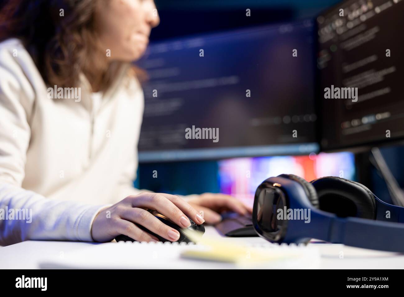 System administrator doing software debugging on PC at home, checking broken lines of code displayed on display. IT expert in living room fixing coding problems, typing on keyboard Stock Photo