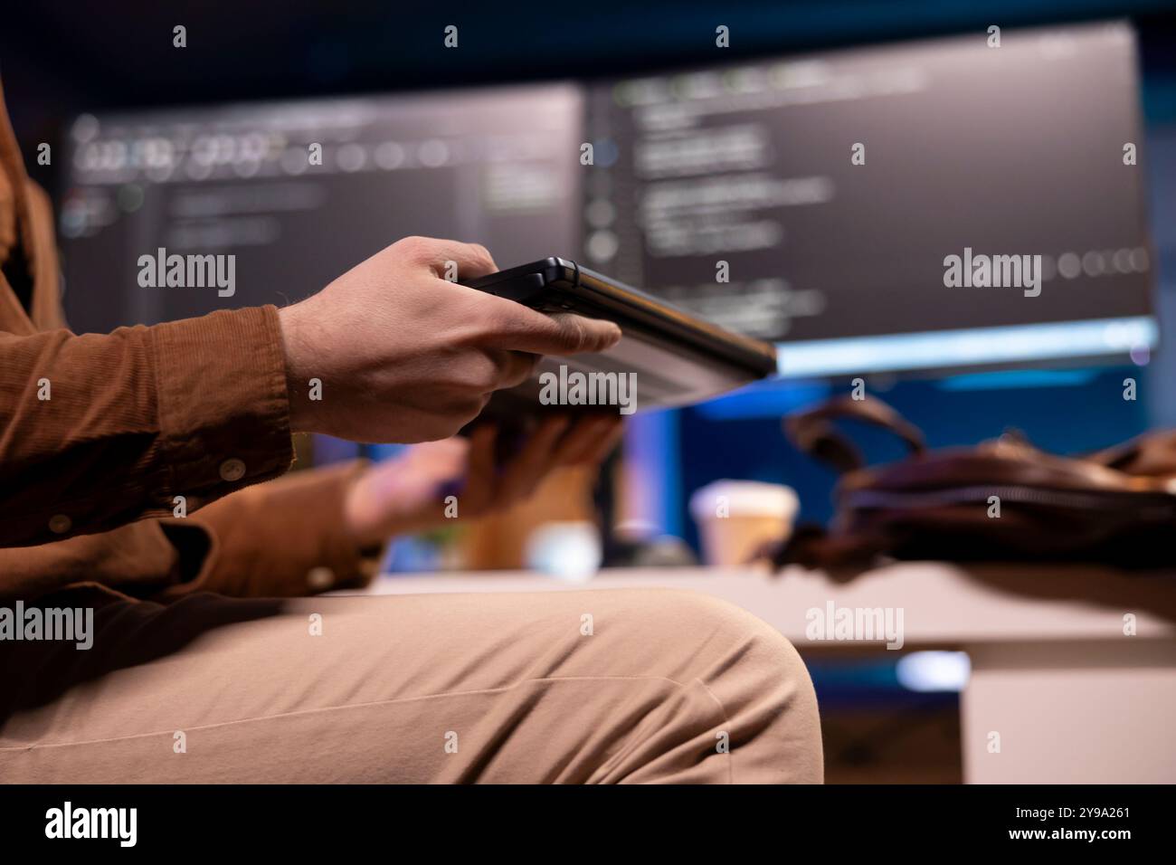 Focus on teleworking software developer working from home opening laptop to write programs in Java programming language on computer monitors in blurry background, close up shot Stock Photo