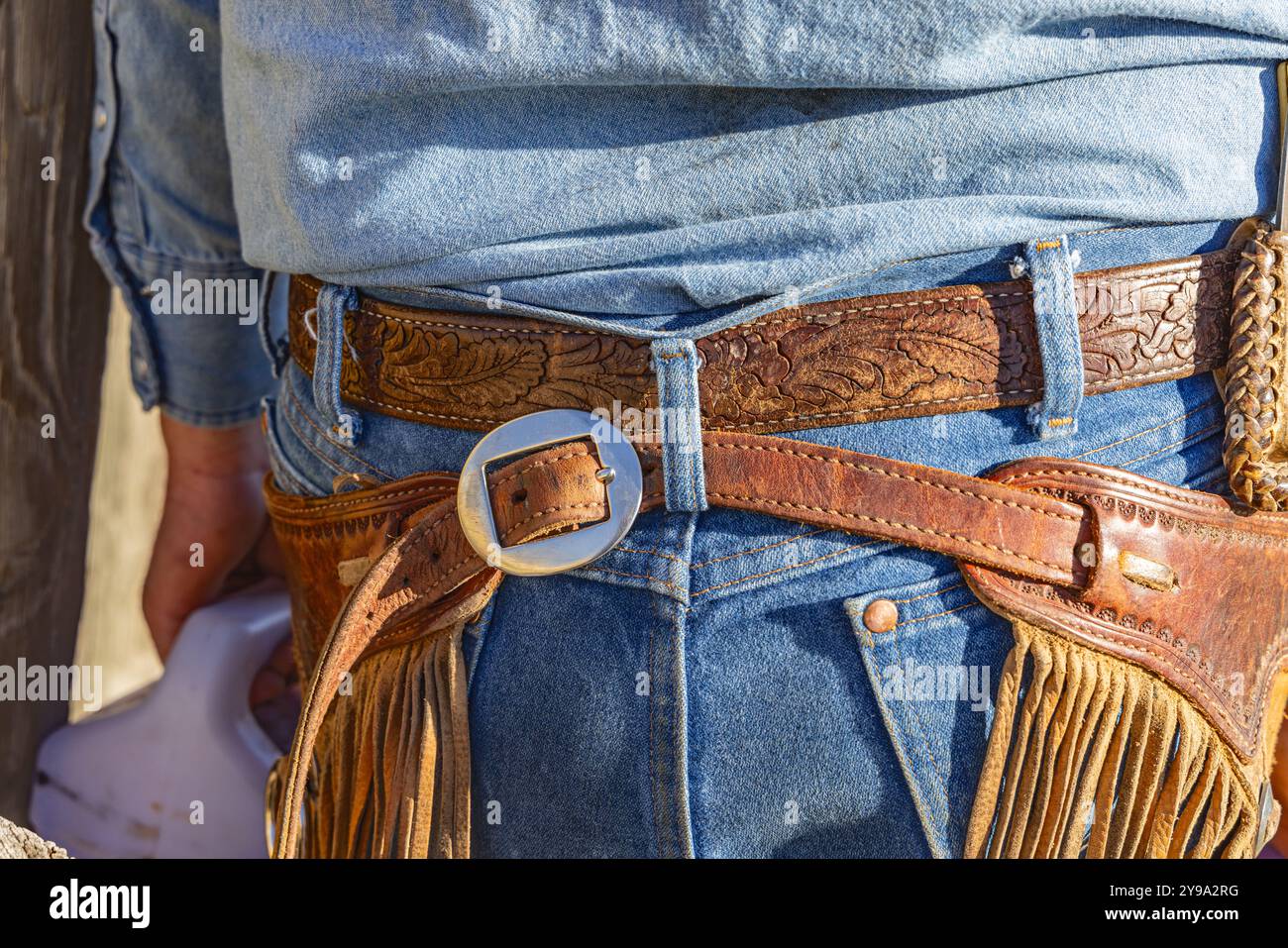 Yoakum, Texas, United States. Cowboy wearing leather chaps and blue jeans. Stock Photo